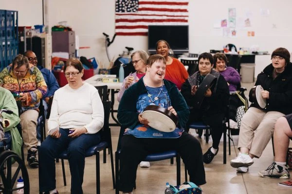 L.I.F.E. Adult day Academy stands listen to music and play percussion